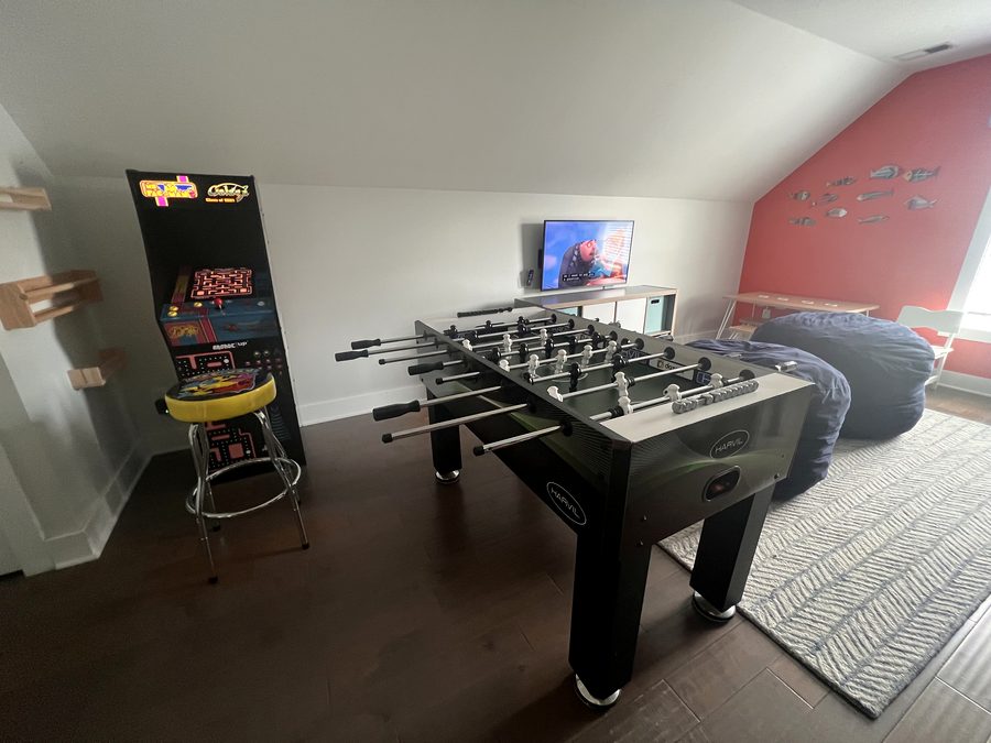 Playroom with arcade machine, foosball and bean bags