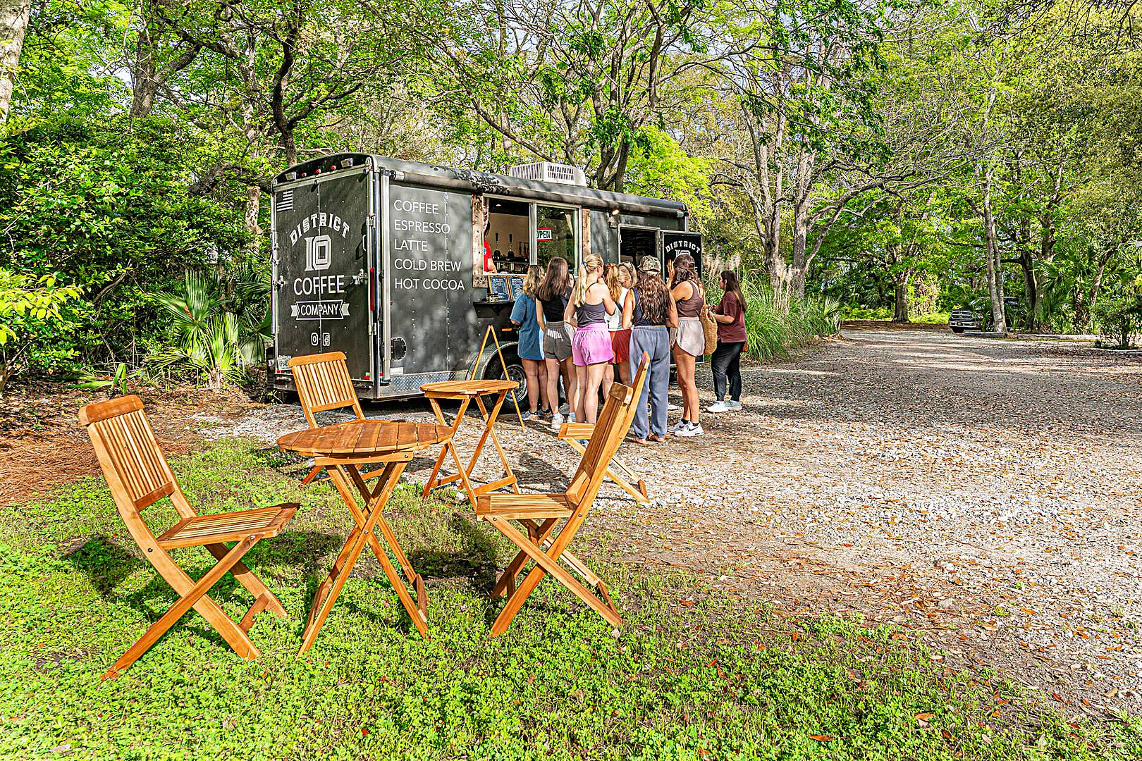 Customers queuing at the District 10 Coffee Company trailer under oak trees on Hilton Head Island